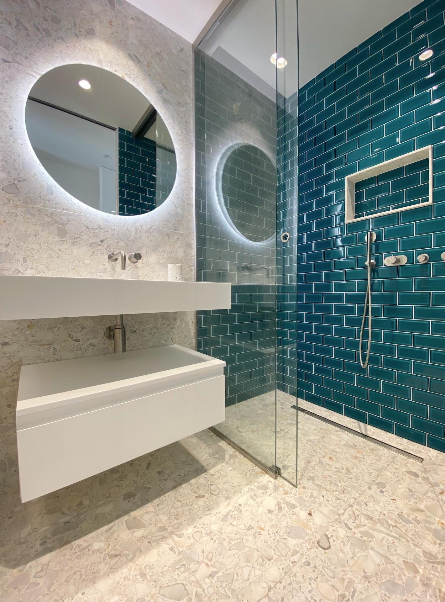 white Corian wall hung basin and white bathroom cabinet from Riluxa in green bathroom designed by Studio Carrez